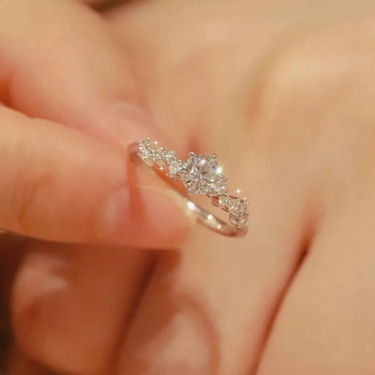 Diamond ring on a finger with a blurred background