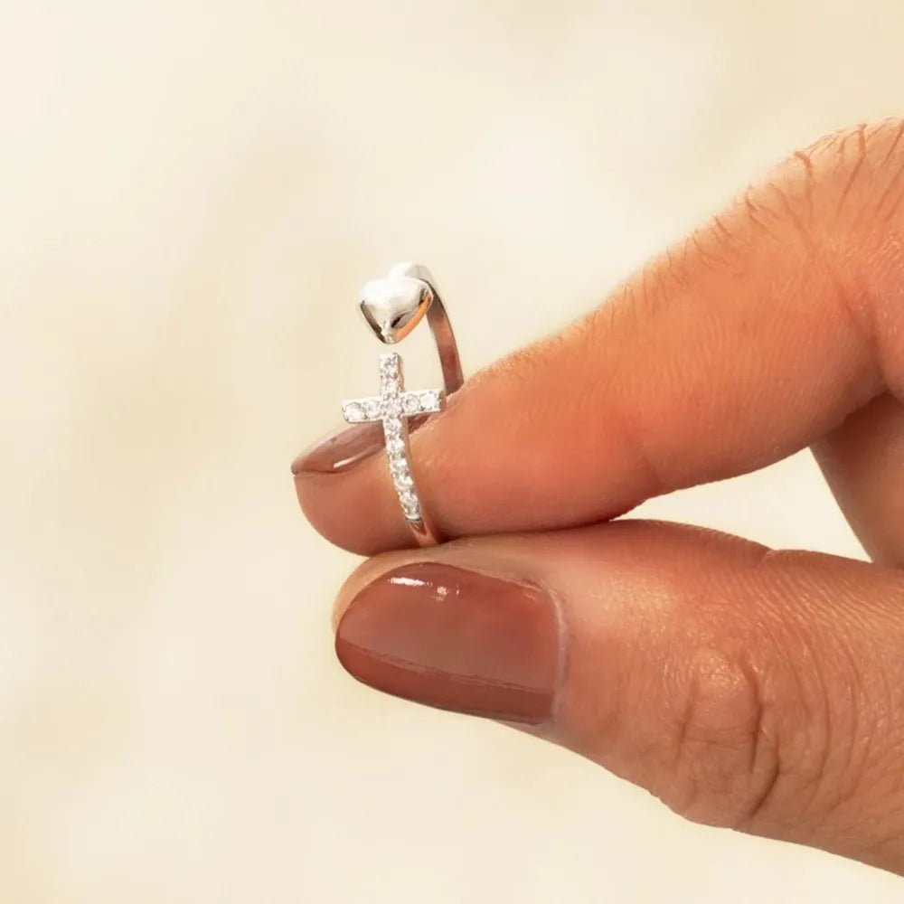 Silver ring with a diamond on a finger against a beige background
