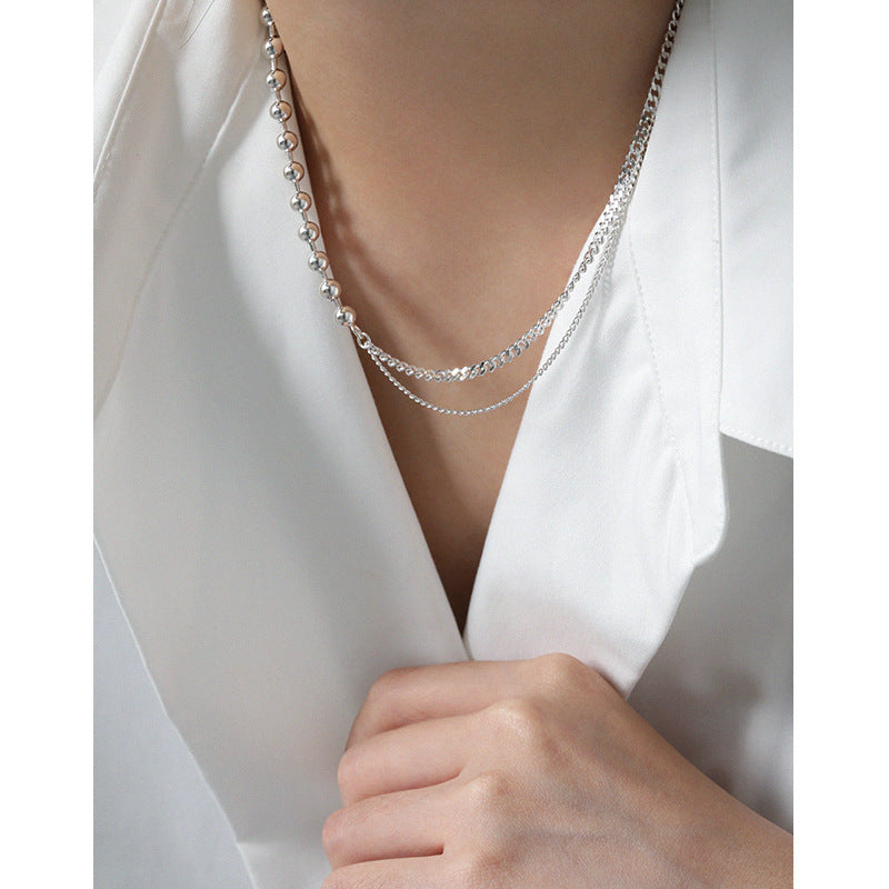 Silver necklace on a white blouse with a blurred background