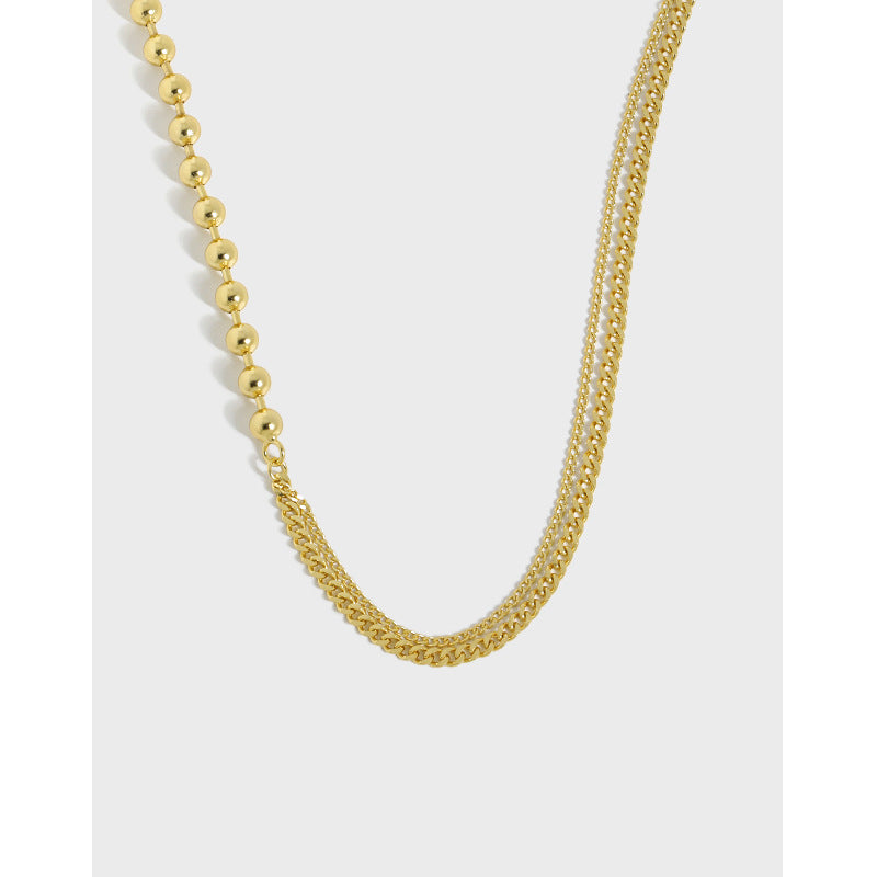 Gold necklace with alternating beaded and chain links on a white background