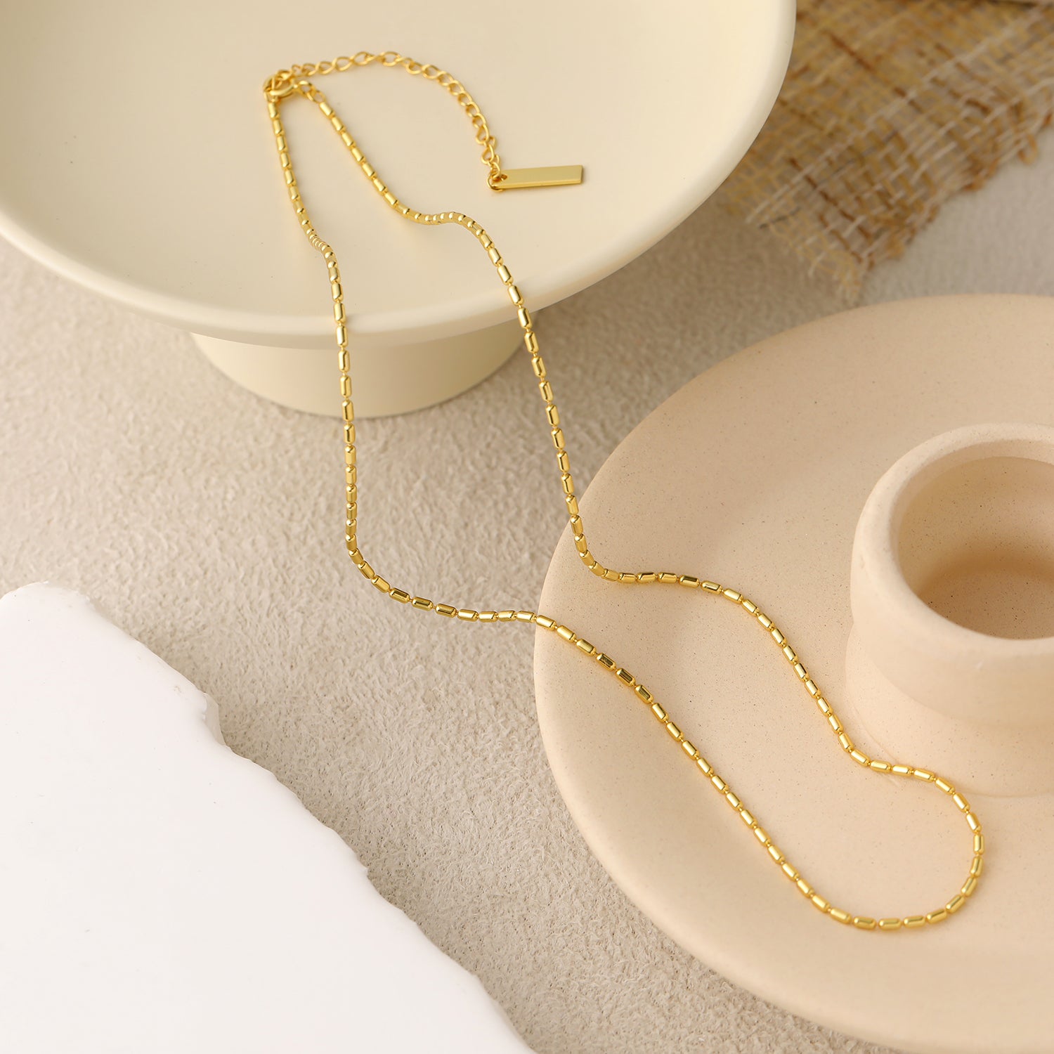 Gold chain necklace on a neutral background