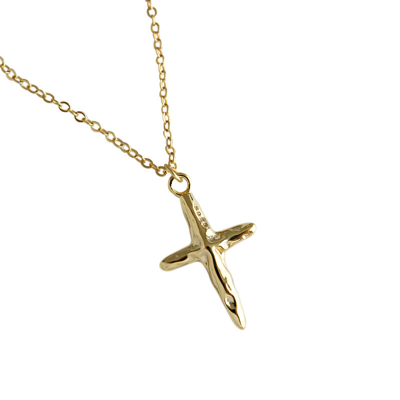 Gold airplane pendant on a chain against a white background