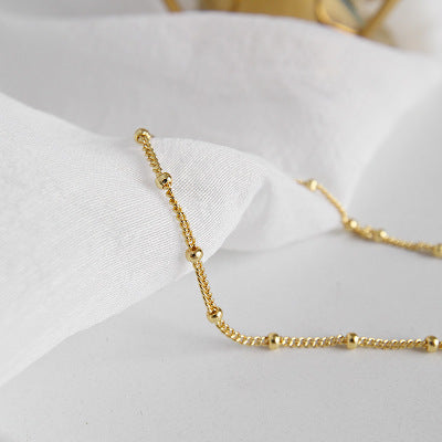 Gold bracelet on a white fabric background