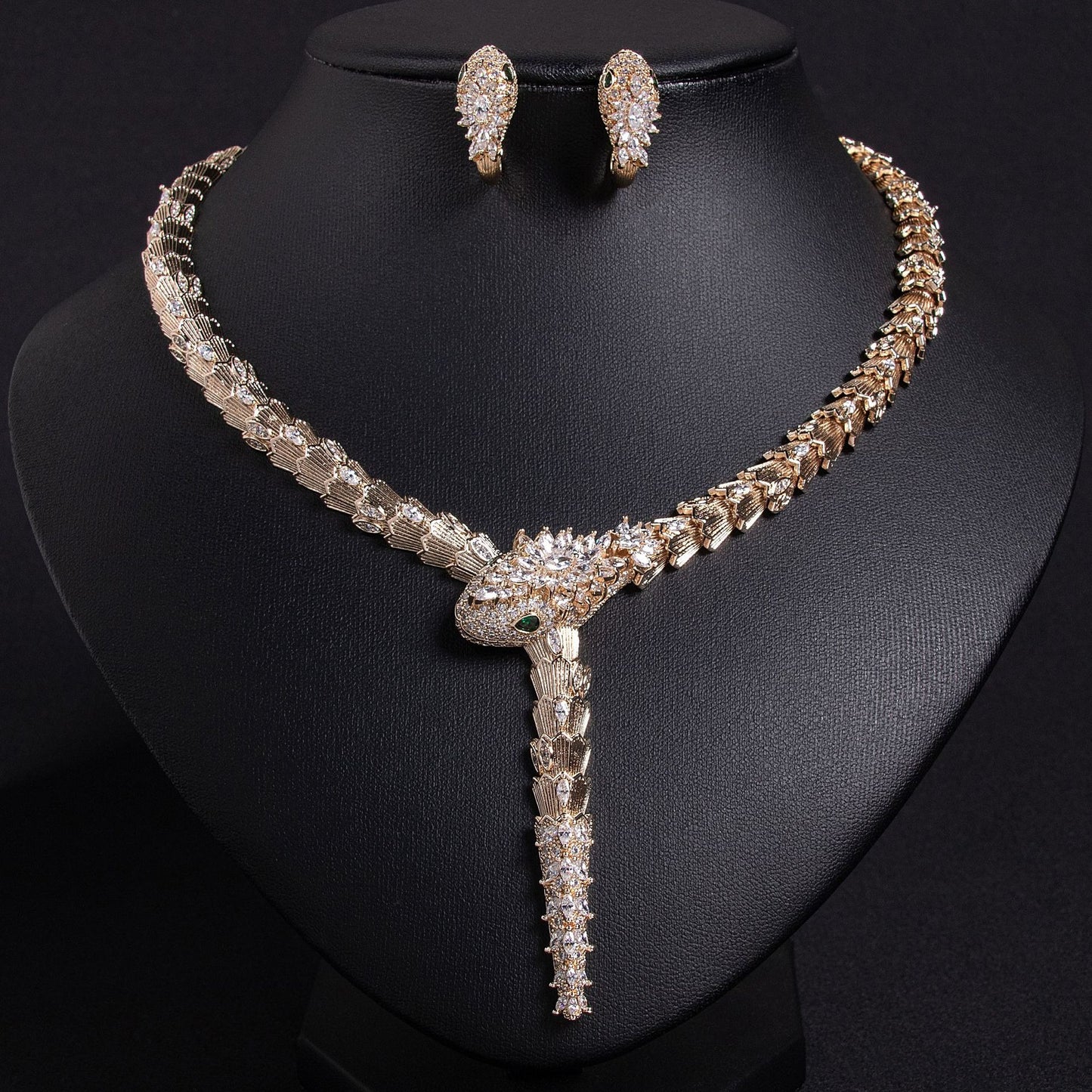 Gold snake necklace with purple and clear stones on a black bust.