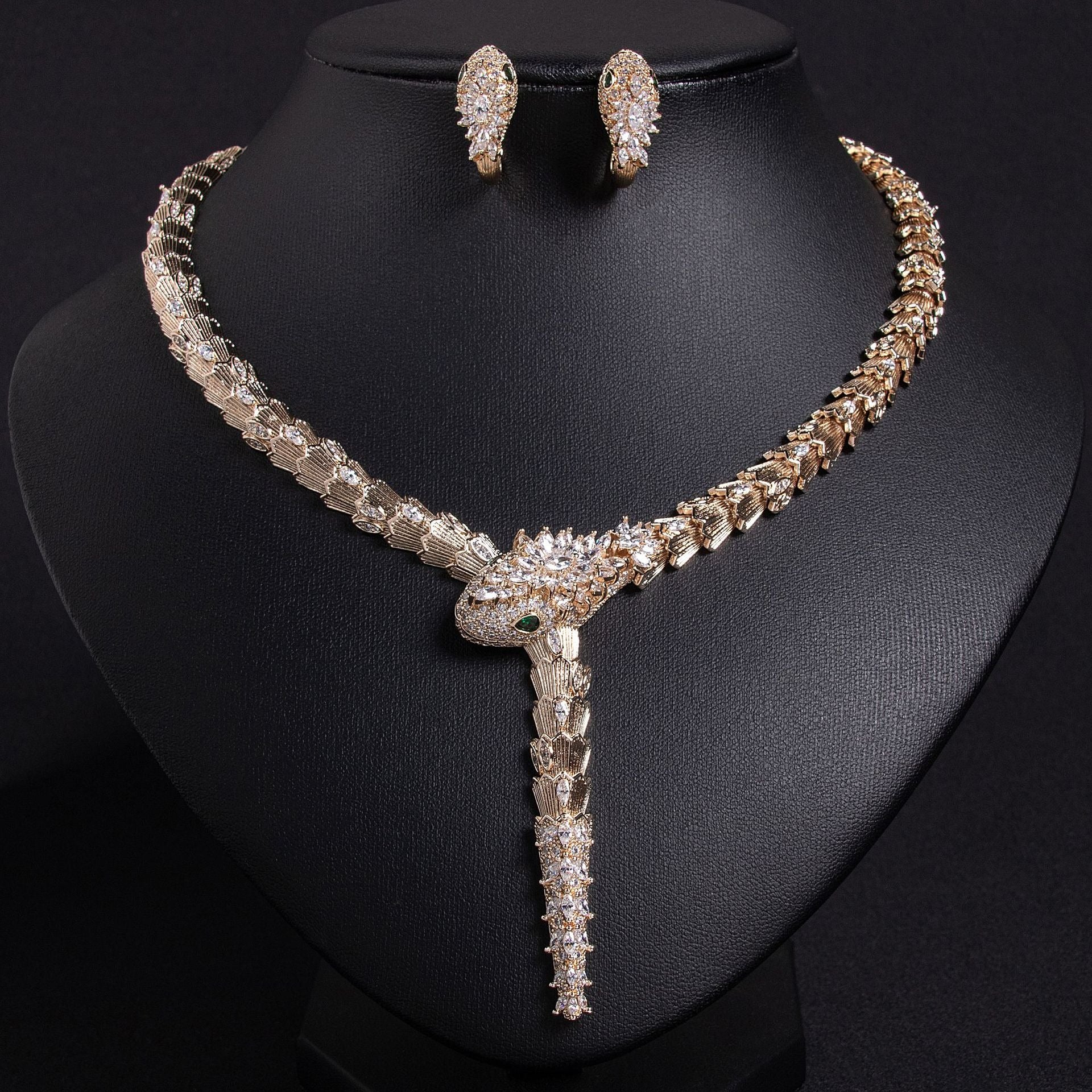 Gold snake necklace with purple and clear stones on a black bust.