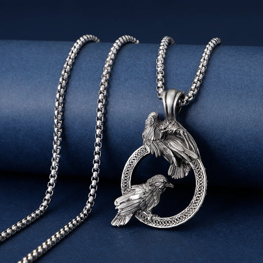 Silver necklace with a detailed pendant featuring two birds on a blue background