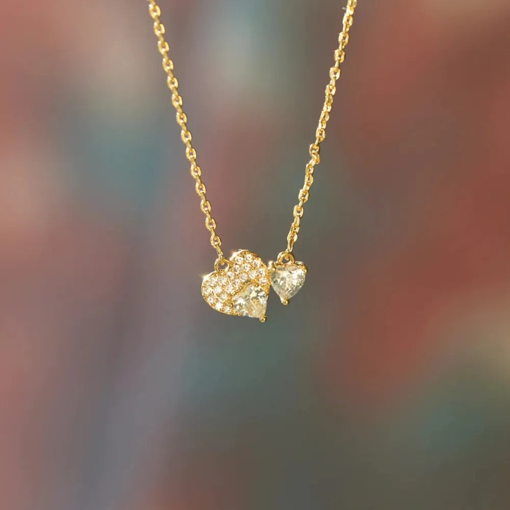 Gold necklace with heart-shaped pendants on a blurred background