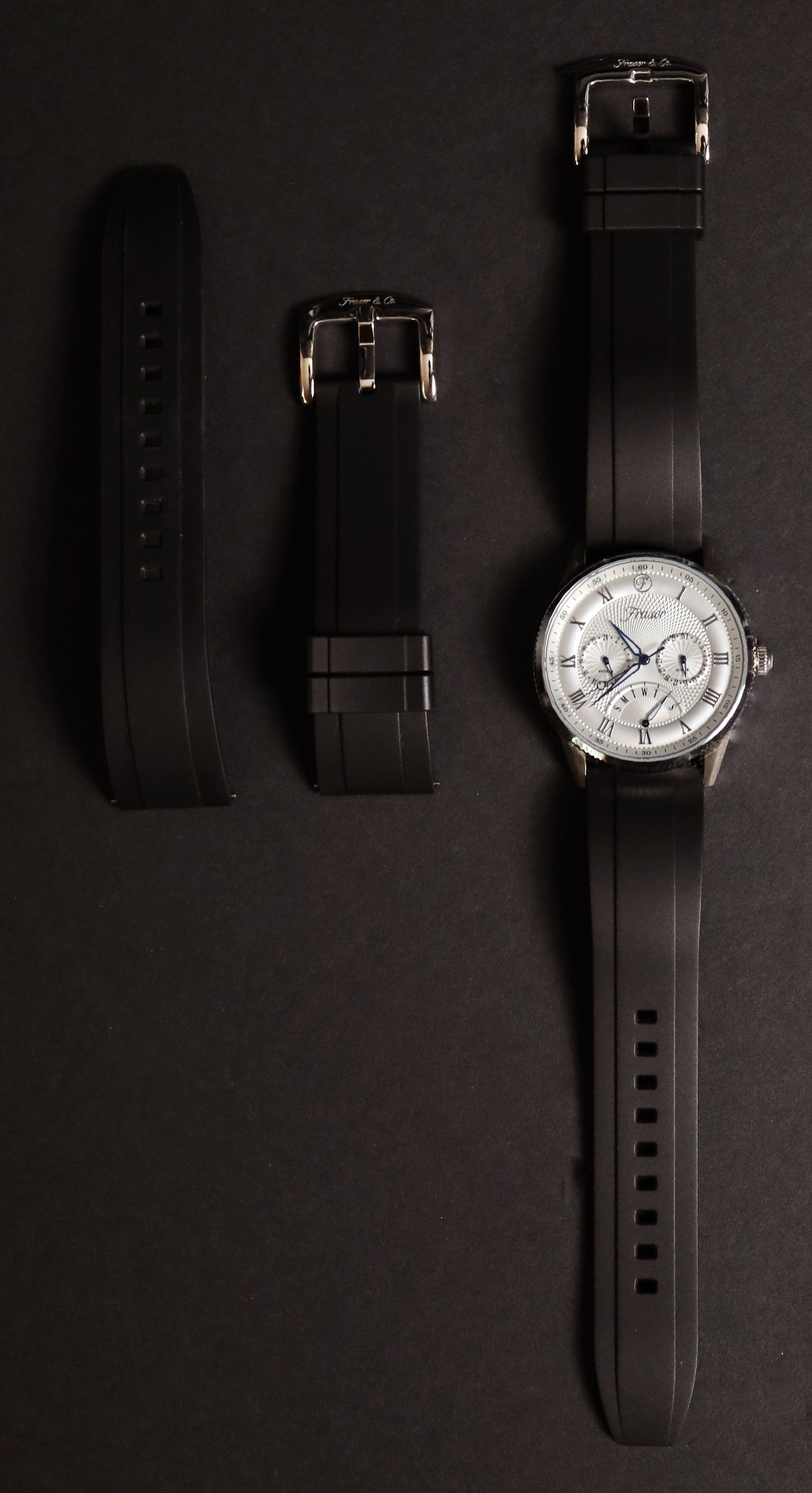 Watch with interchangeable straps on a dark background