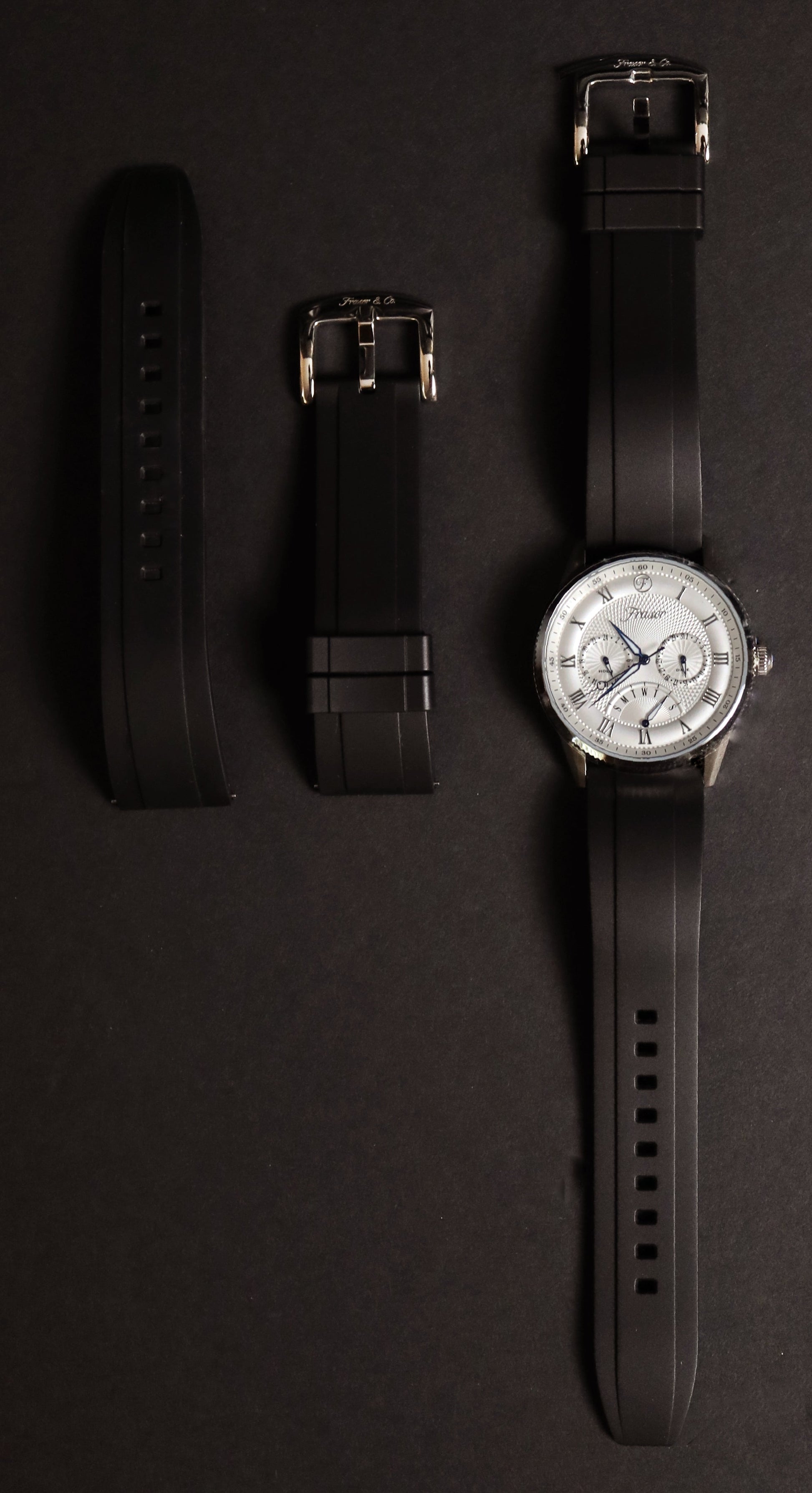 Watch with interchangeable straps on a dark background