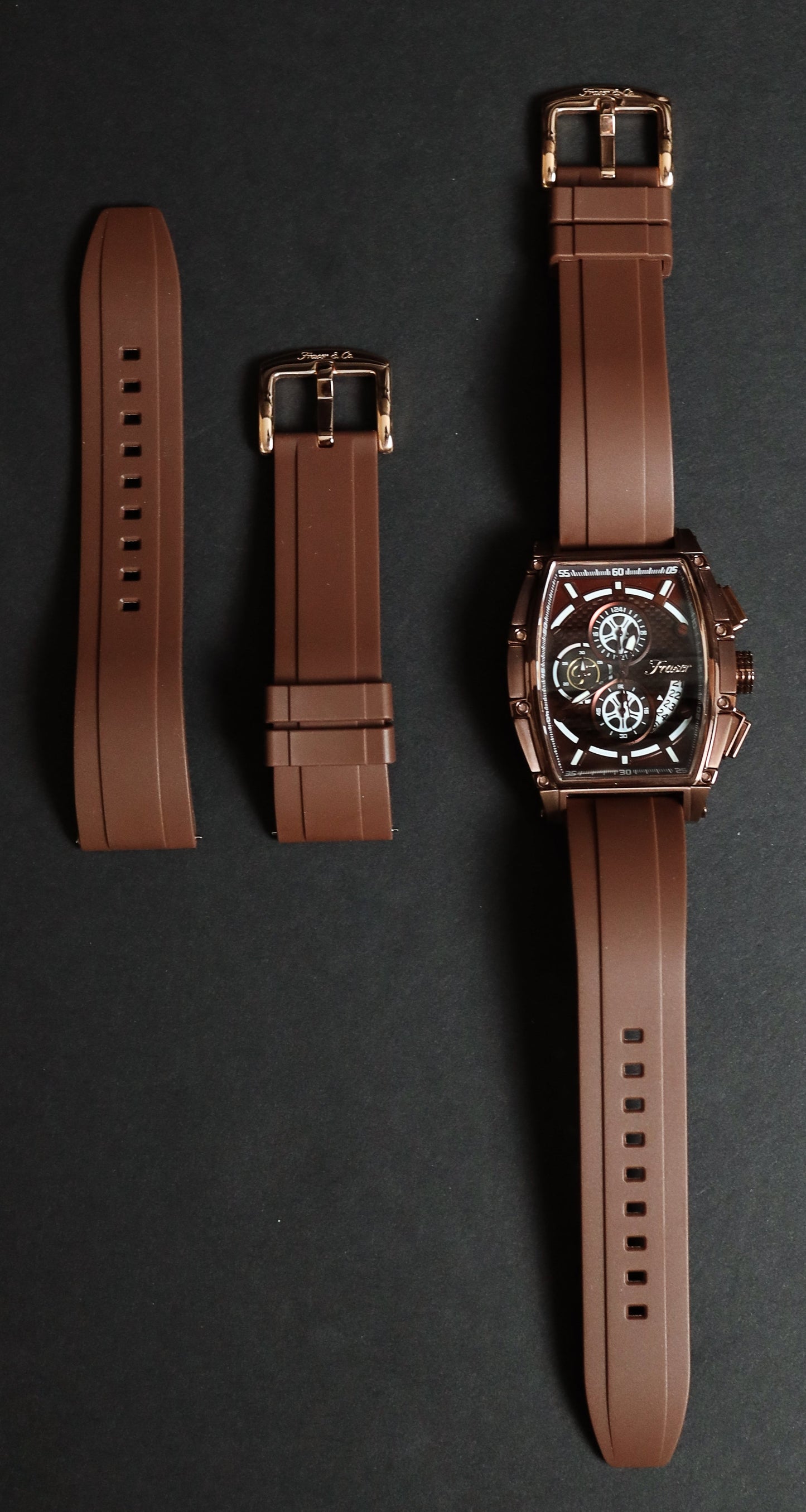 Brown watch with interchangeable straps on a dark background