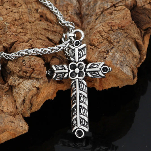Silver cross pendant necklace on a wooden surface