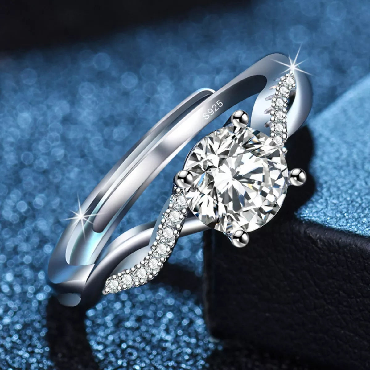 Silver ring with a large diamond on a blue glittery background