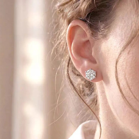 Close-up of an ear wearing a diamond stud earring with a blurred background