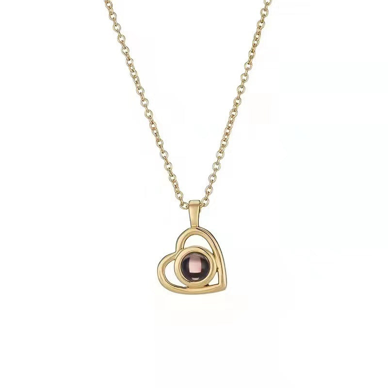 Gold necklace with a heart-shaped pendant on a white background