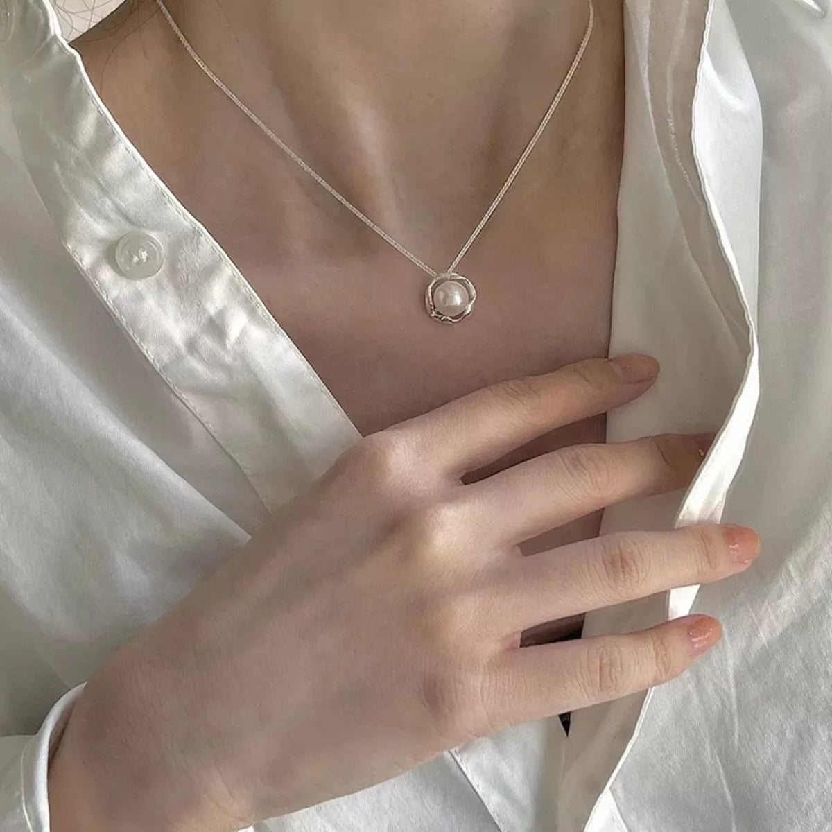 Pearl necklace worn by a person with a white shirt