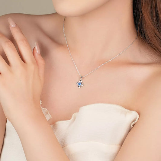 Necklace with a blue pendant worn by a person, with a neutral background