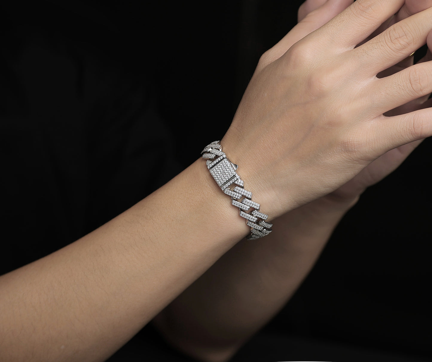 Silver bracelet on a wrist with a dark background