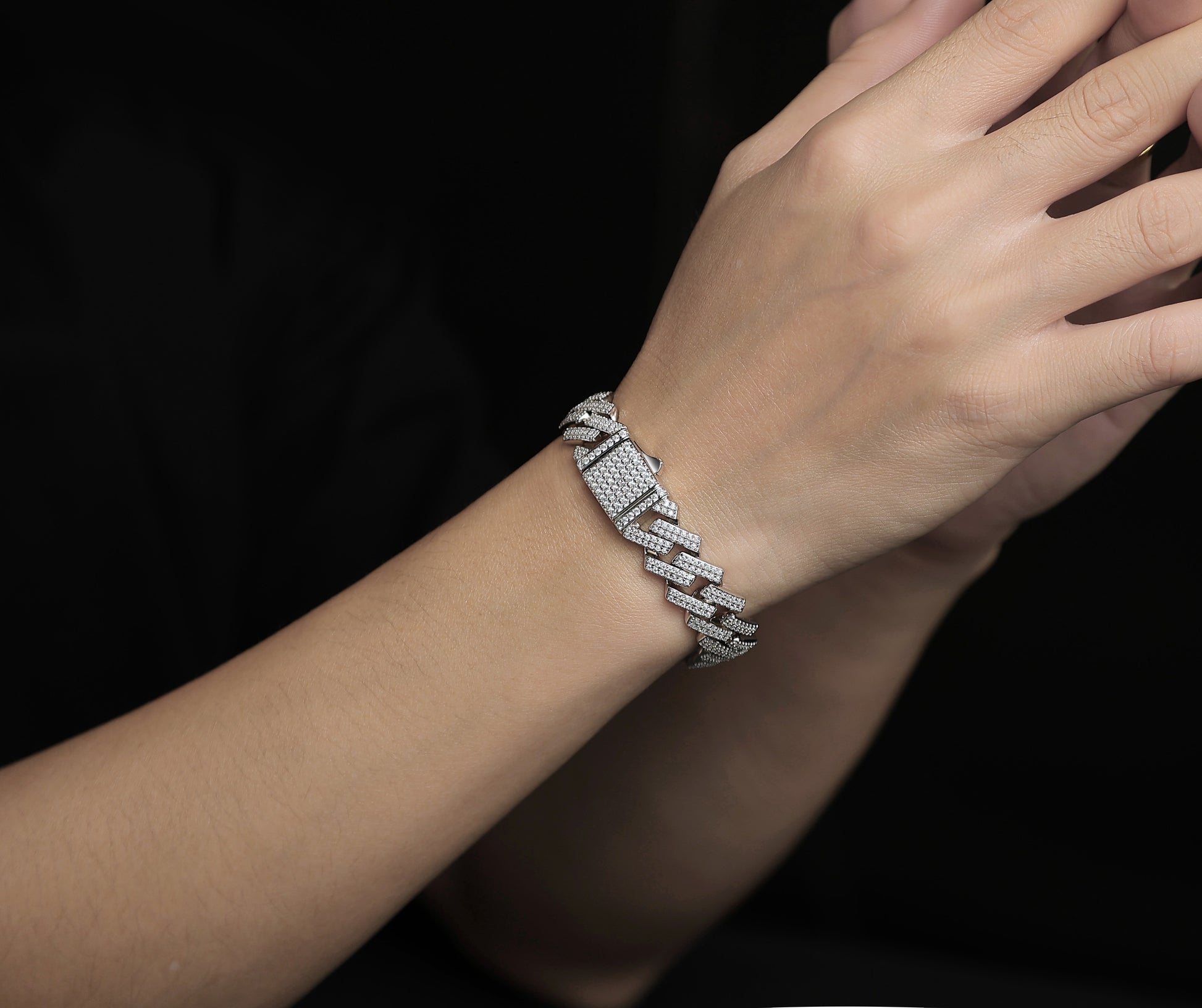 Silver bracelet on a wrist with a dark background