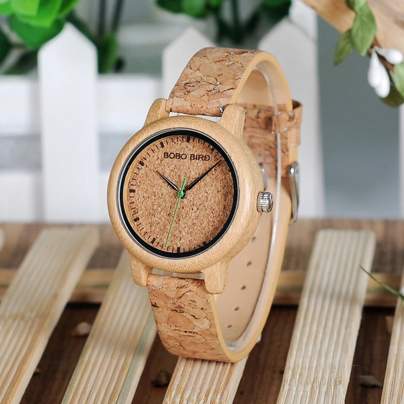 Wooden watch with cork strap on a wooden surface with blurred greenery in the background