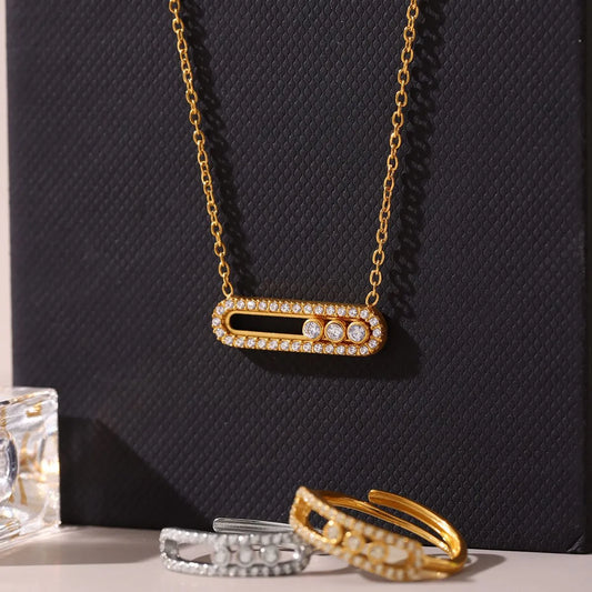 Gold necklace with diamond accents on a dark textured background