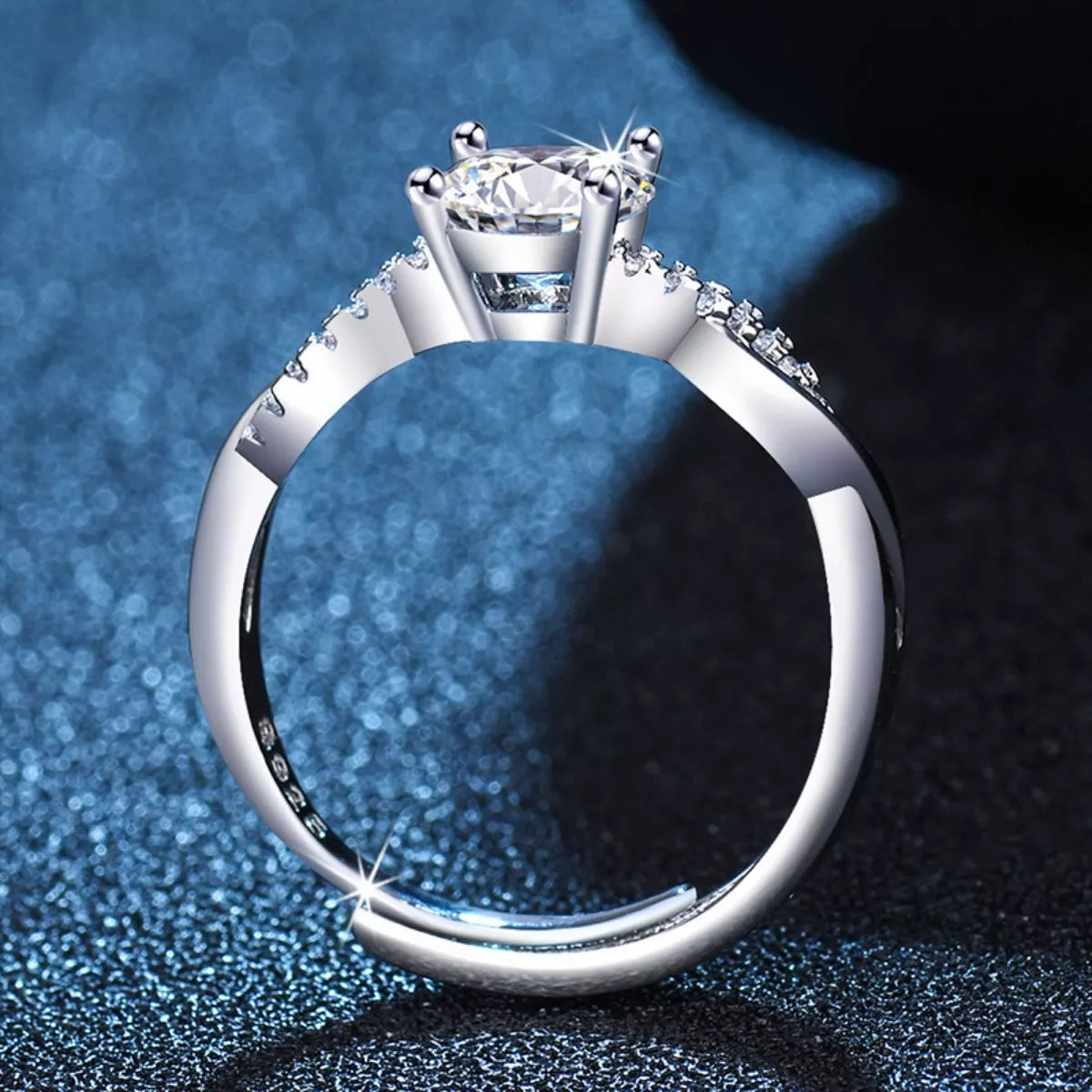 Silver ring with a diamond on a textured blue and black background