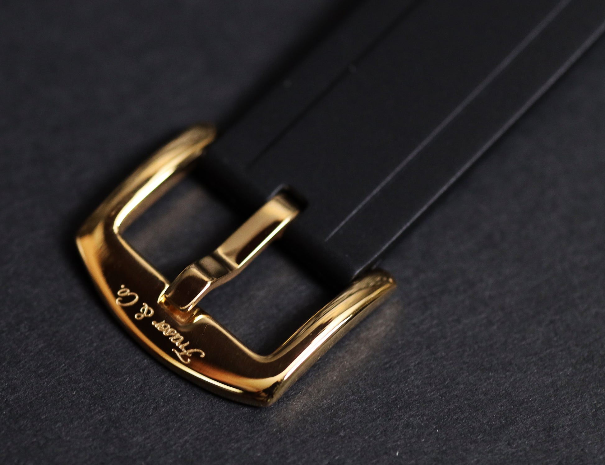 Gold belt buckle on a black leather strap