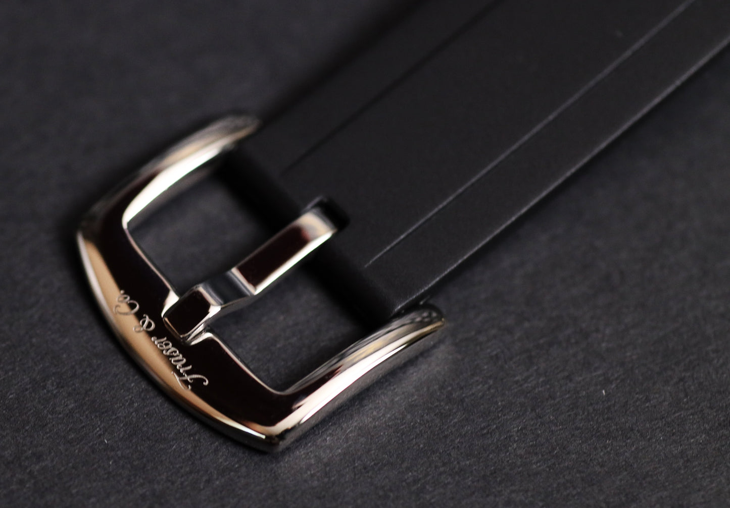 Close-up of a silver buckle on a black leather strap