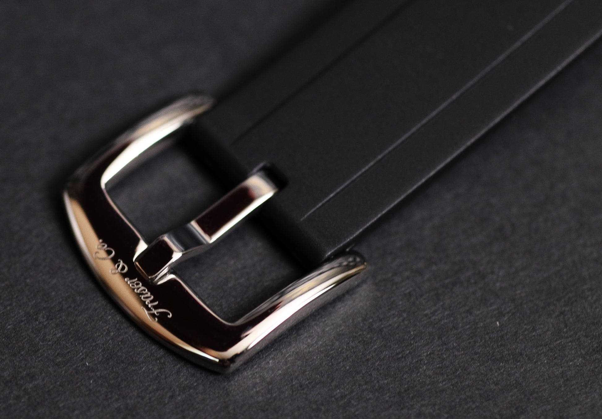 Close-up of a silver buckle on a black leather strap